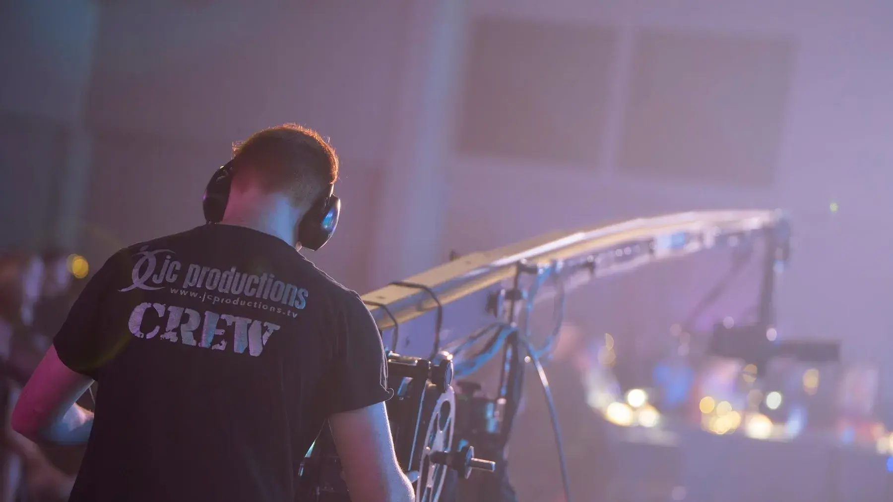 JC Productions camera crane operator working beside a live stage