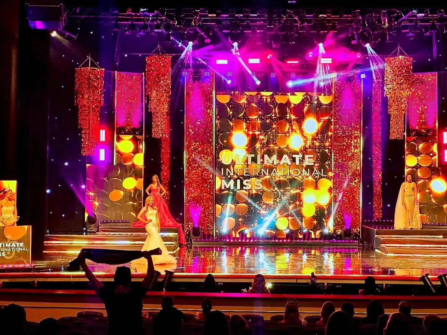 Bold, high-energy pageant stage with illuminated vertical screens and a central video wall