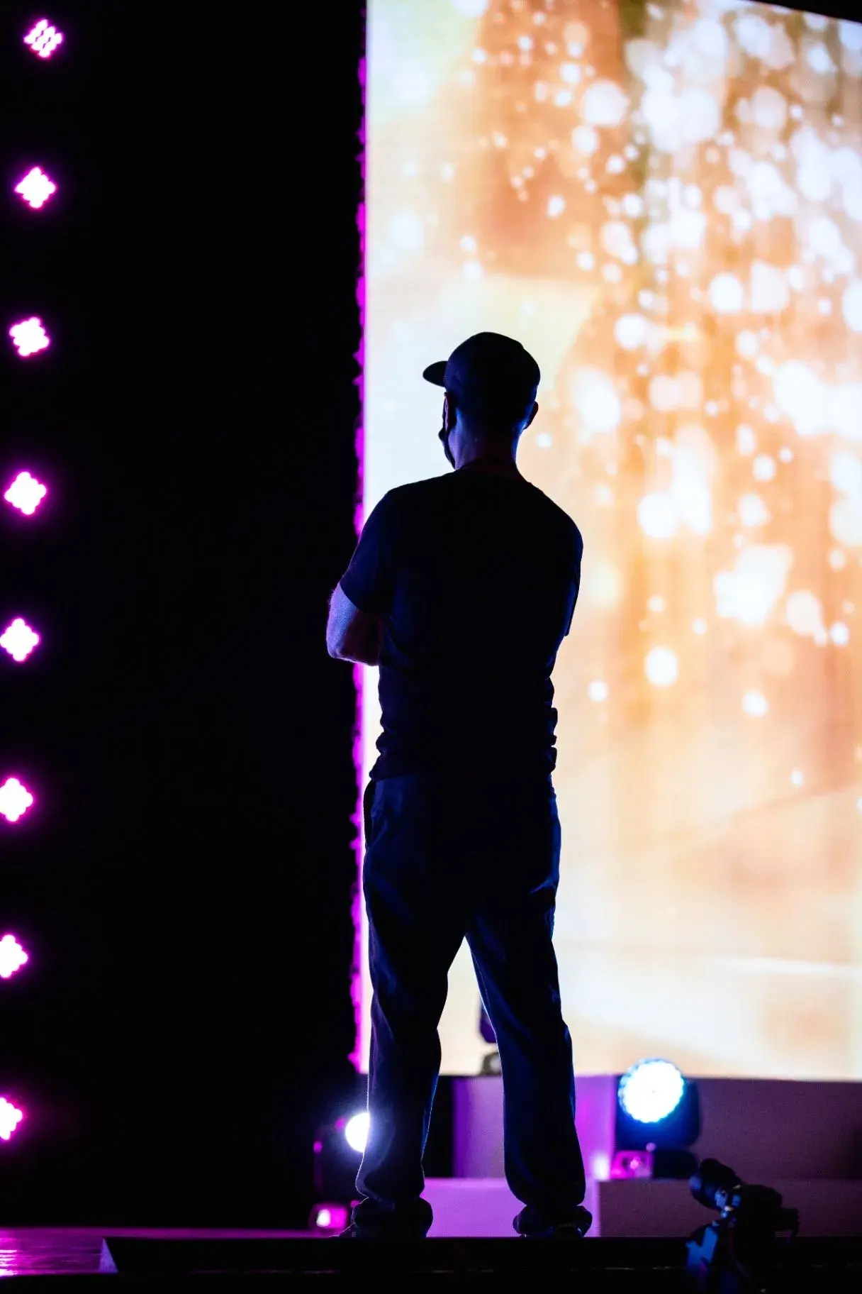 Operator beside a large video screen backstage